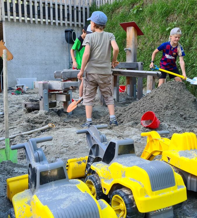 Kinder buddeln im Sand und bauen Burgen